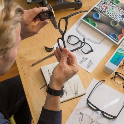 designer occhiali designer assembra prototipo di occhiali. Aeonvis ha implementato SAP Fashion Management Solution su HANA Enterprise Cloud per supportare la crescita globale di Kering Eyewear.